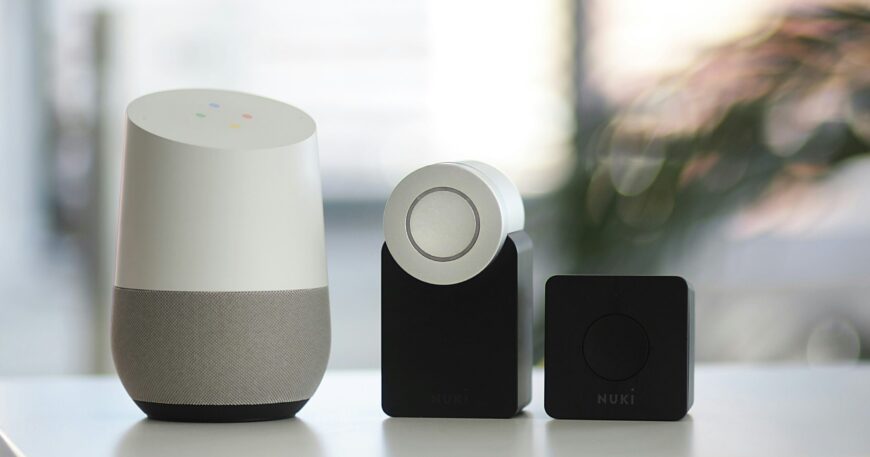 white and gray Google smart speaker and wo black speakers